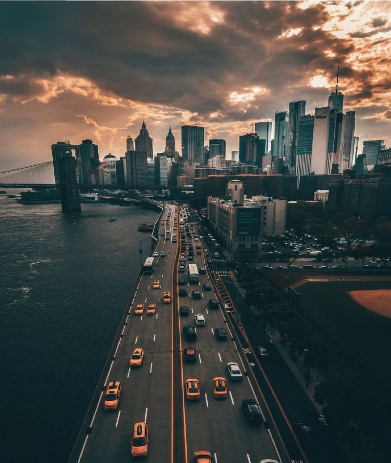 Aerial view of a city skyline at dusk with traffic crossing a bridge