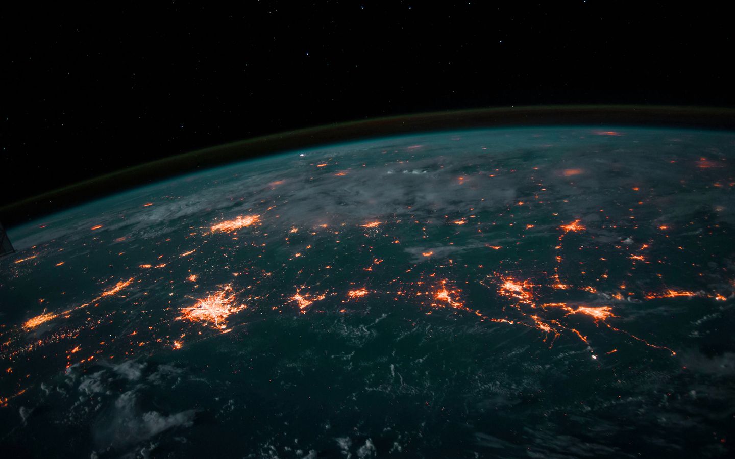 The curve of the Earth seen from orbit, city lights glowing orange